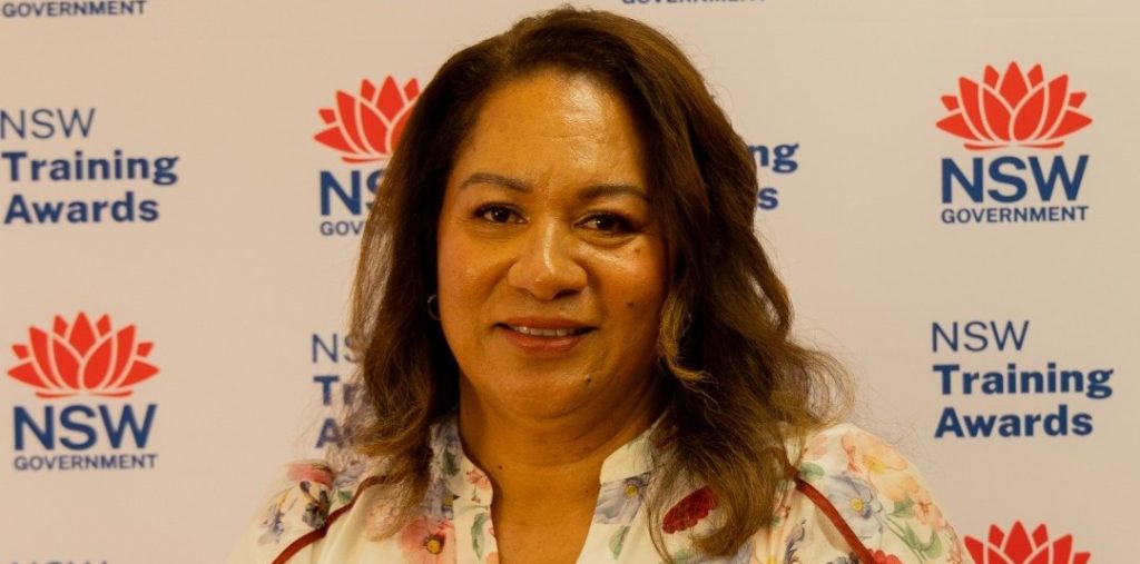 Woman smiling at NSW Training Awards event for education excellence.